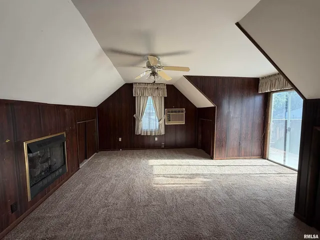 a view of an empty room with window and fireplace