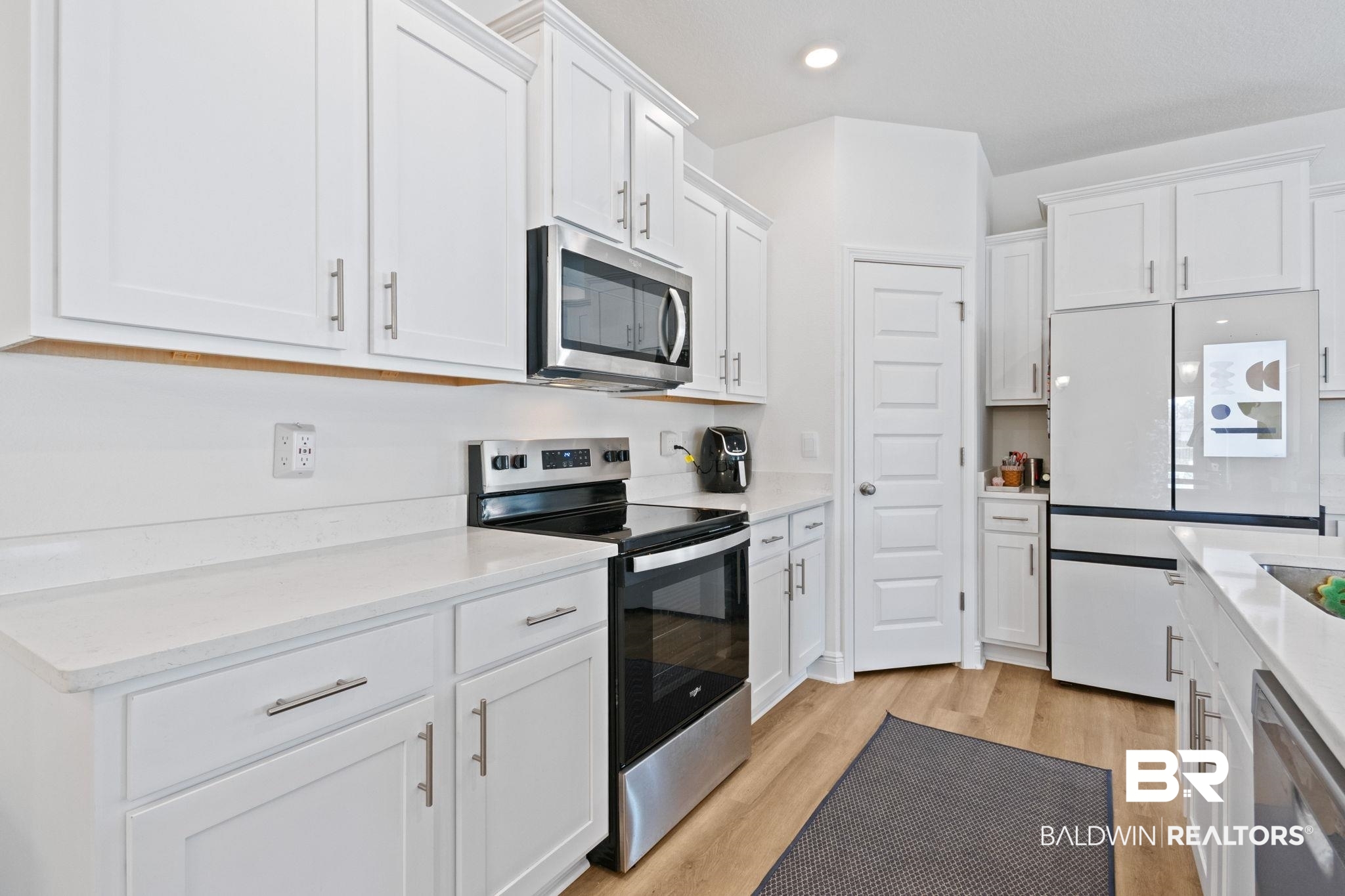 12919 Torrent Road Fairhope, AL 36532 - Photo 25 of 74 Kitchen featuring stainless steel appliances, white cabinetry, light wood-type flooring, light stone counters, and recessed lighting