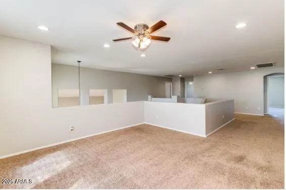 an empty room with windows and fan