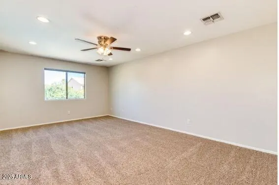 an empty room with windows and ceiling fan