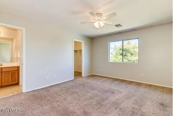 an empty room with closet and a ceiling fan