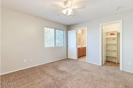 an empty room with windows and ceiling fan