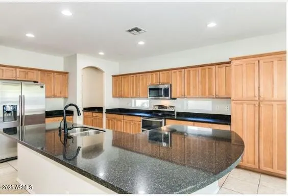 a kitchen with stainless steel appliances granite countertop a sink a stove and a refrigerator