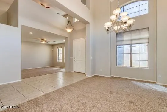 an empty room with windows and ceiling fan