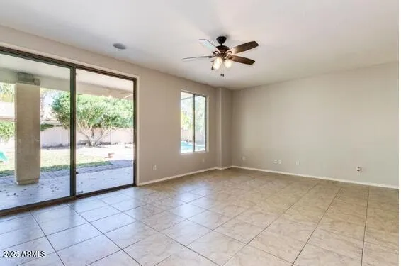 an empty room with a ceiling fan and view of a bathroom
