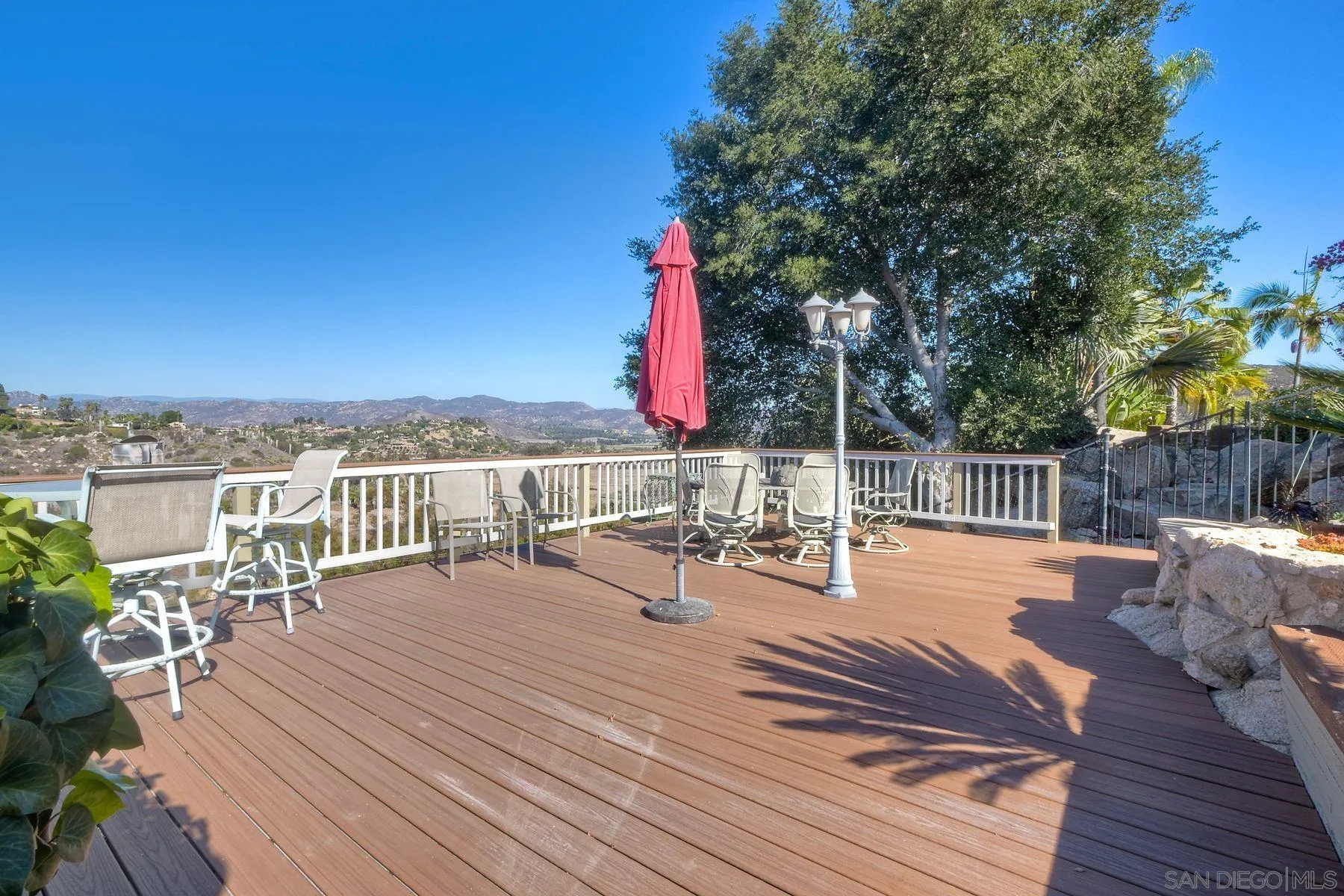 2848 Sunset Hills Escondido, CA 92025 - Photo 6 of 67 a view of a roof deck with table and chairs a barbeque with wooden floor and fence