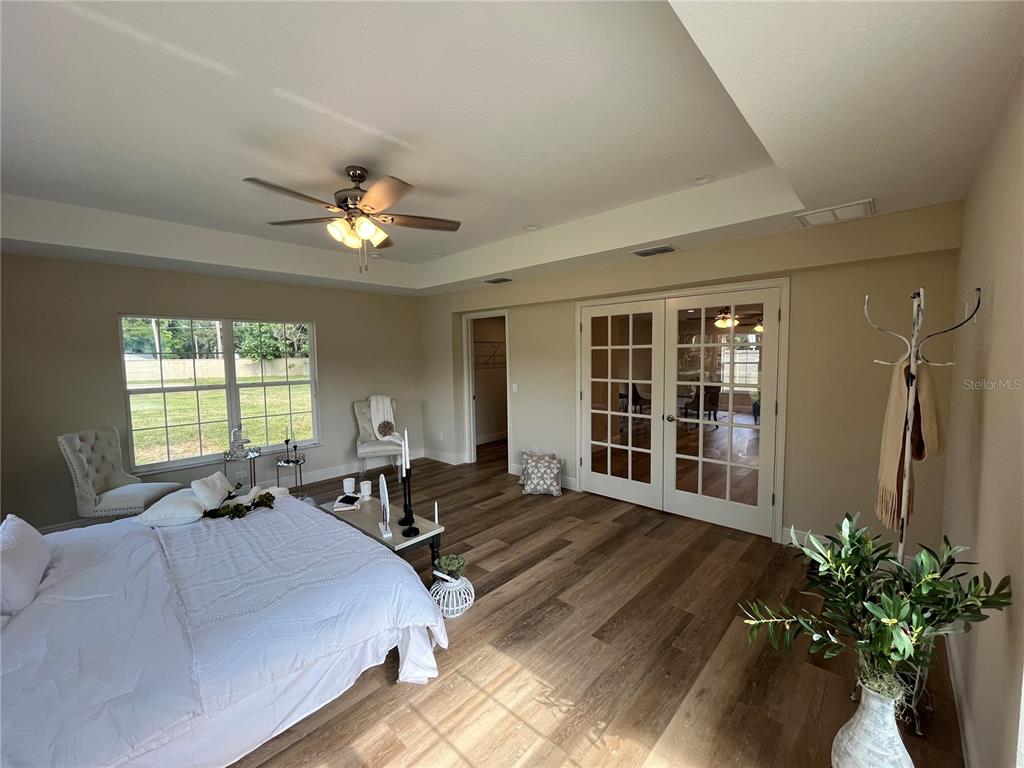 274 Southeast 34th Place Ocala, FL 34471 - Photo 44 of 97 a spacious bedroom with a balcony a bed and a chandelier