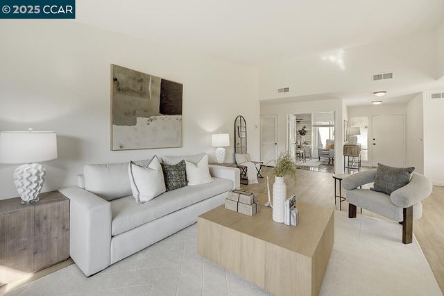 a living room with furniture a fireplace and potted plants
