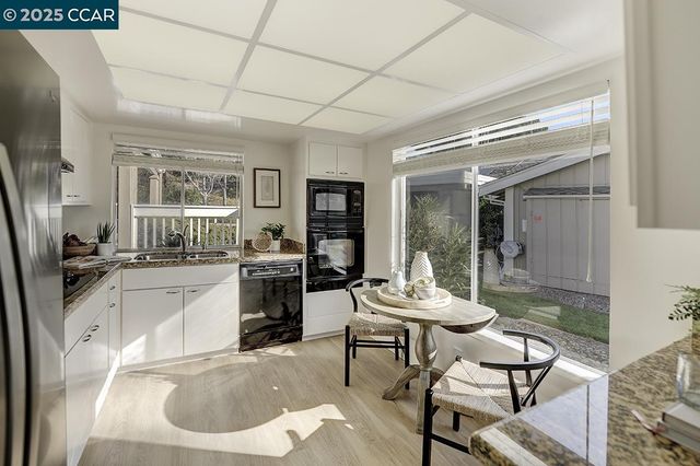 a kitchen with granite countertop a sink a stove and refrigerator
