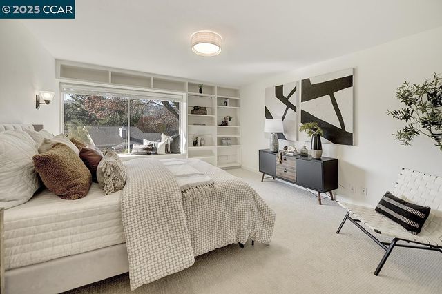 a bedroom with a bed and dresser with wooden floor