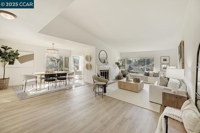 a living room with furniture a fireplace and a floor to ceiling window