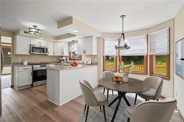 a kitchen with kitchen island white cabinets and refrigerator