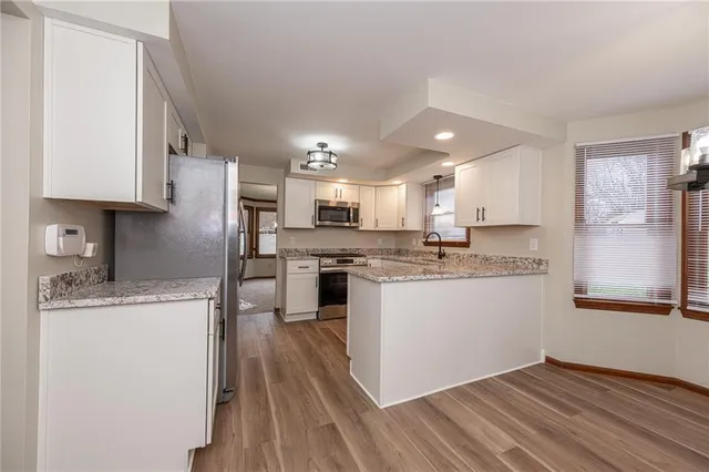 a kitchen with stainless steel appliances granite countertop a sink refrigerator and microwave