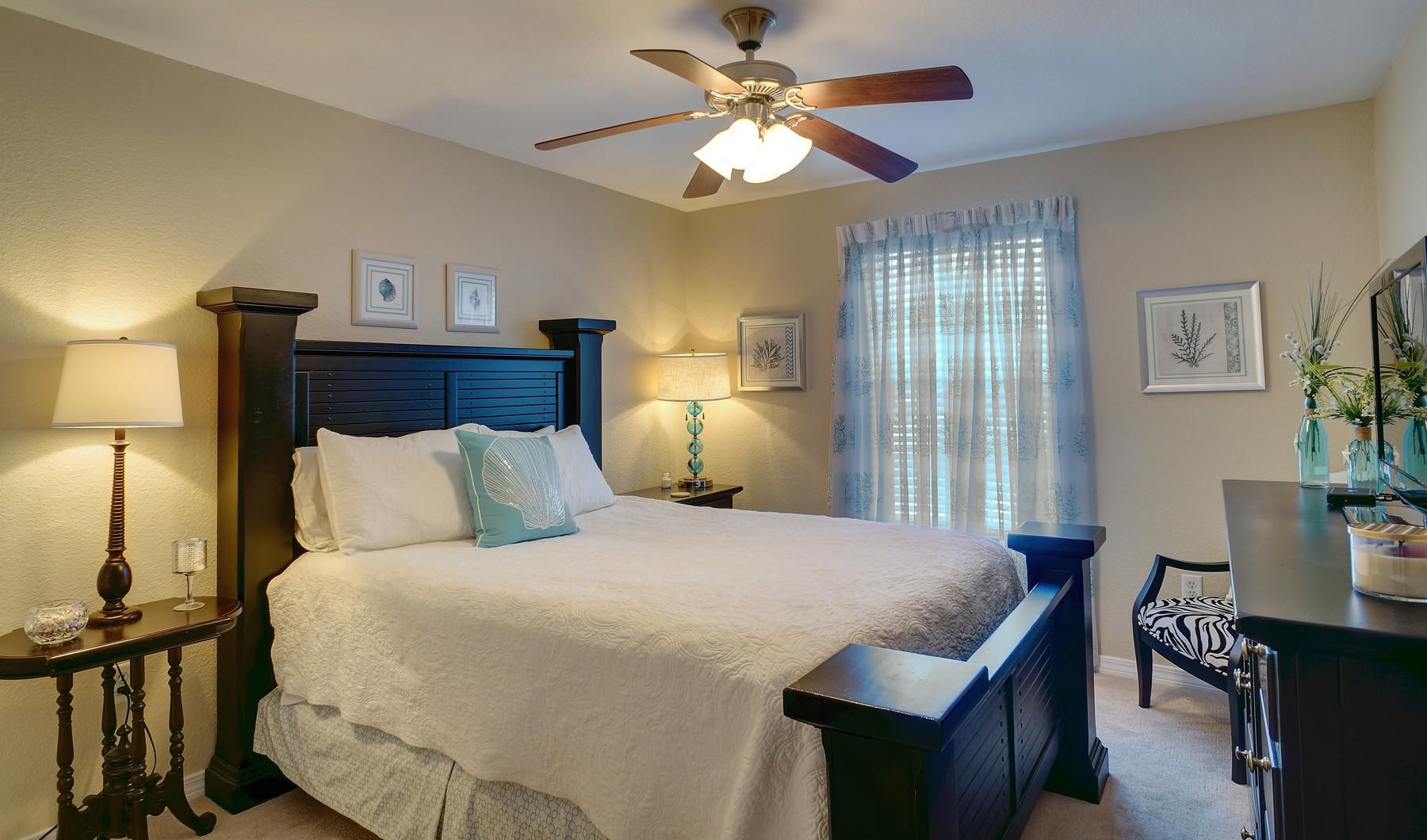 588 East Shipwreck Road Santa Rosa Beach, FL 32459 - Photo 18 of 29 a bedroom with a bed and a chandelier