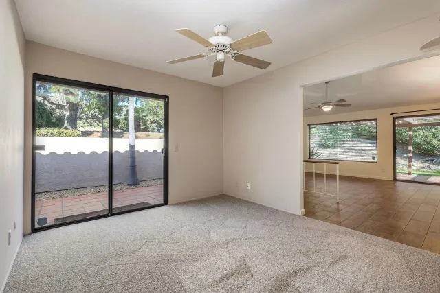 an empty room with windows and ceiling fan