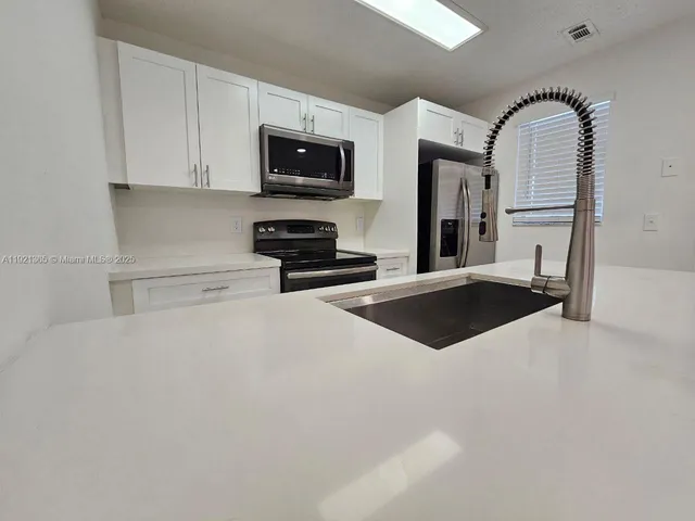 a view of kitchen refrigerator and microwave