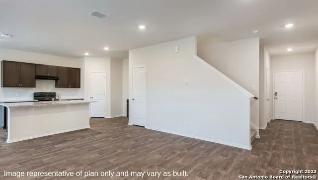 a view of a kitchen with wooden floor and electronic appliances