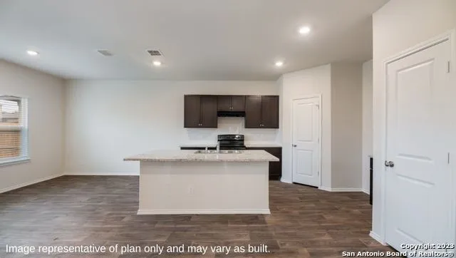 a view of kitchen with cabinets microwave and stove