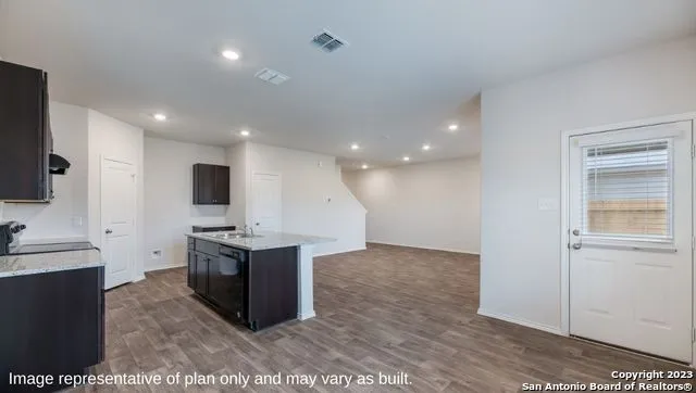 a kitchen with a sink and a stove top oven with wooden floor