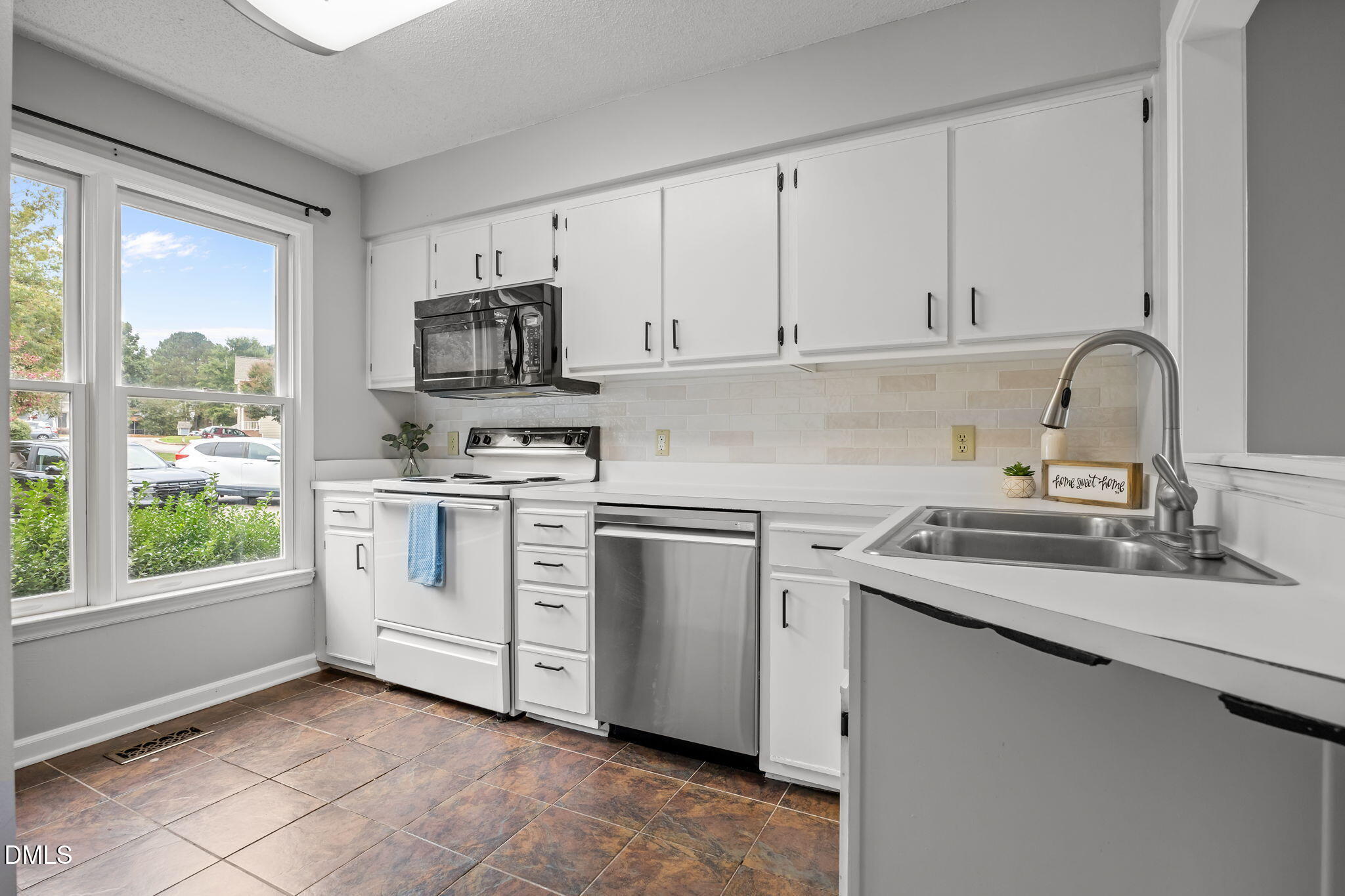 1626 Oakland Hills Way Raleigh, NC 27604 - Photo 8 of 23 a kitchen with white cabinets a sink and a stove