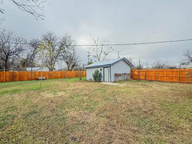 a view of backyard with wooden fence