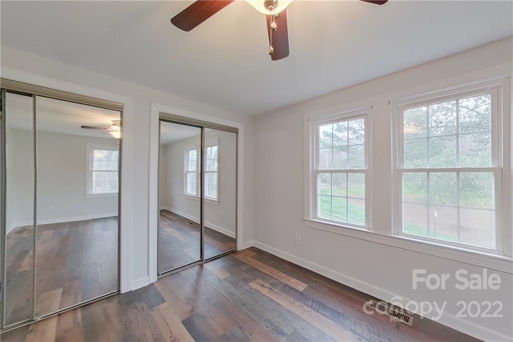 3701 Parkwood School Road Monroe, NC 28112 - Photo 13 of 36 an empty room with wooden floor fan and windows
