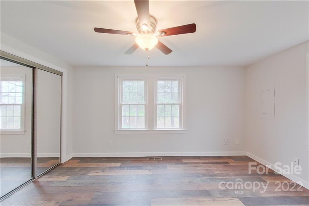 3701 Parkwood School Road Monroe, NC 28112 - Photo 33 of 36 an empty room with wooden floor chandelier fan and windows
