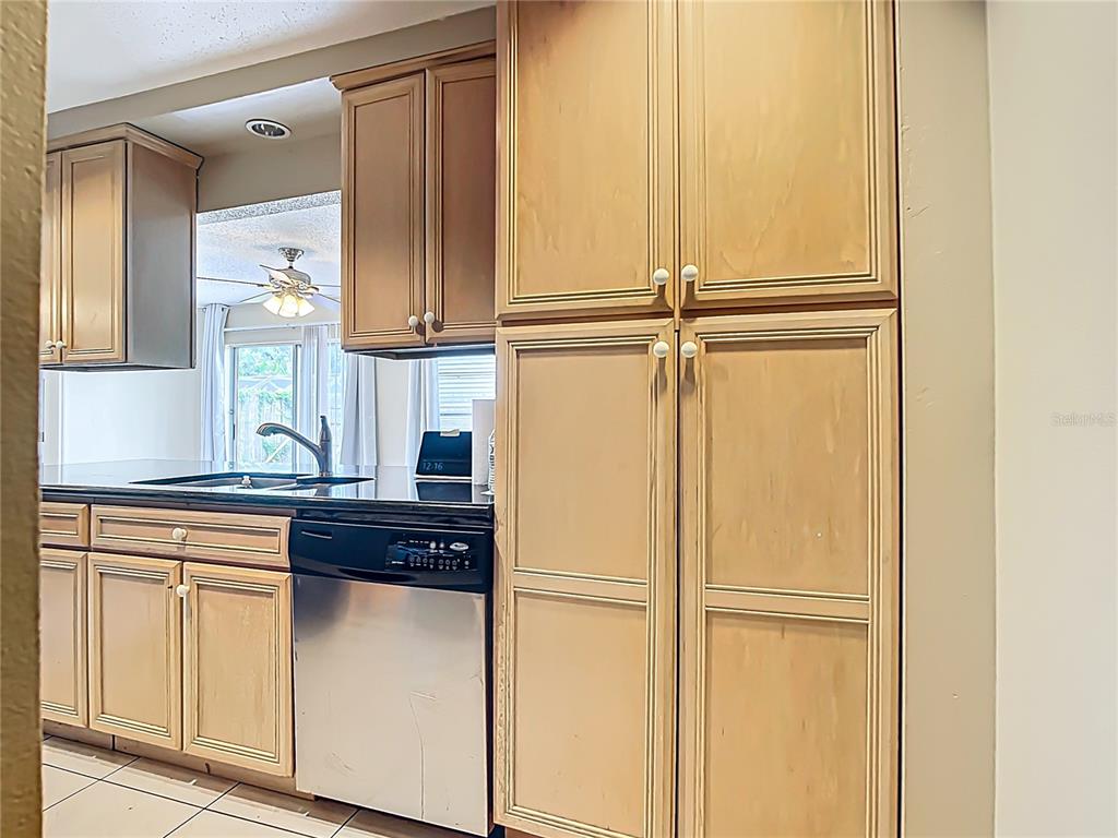 5964 Diana Road Venice, FL 34293 - Photo 15 of 27 a kitchen with a refrigerator and white cabinets