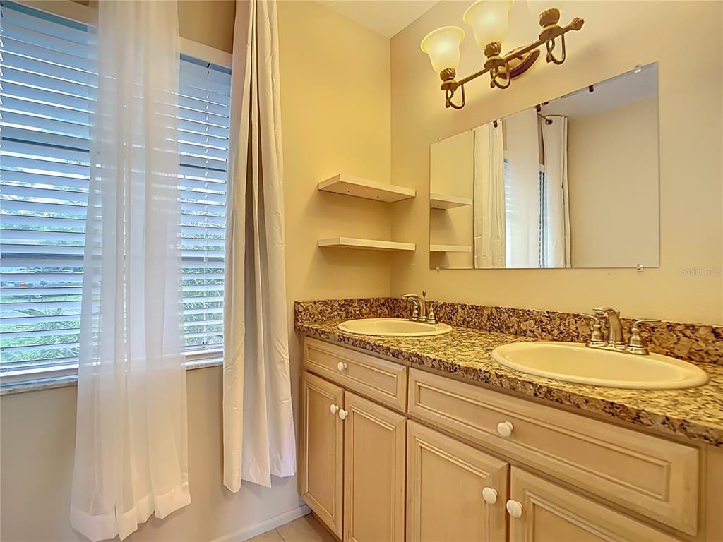 5964 Diana Road Venice, FL 34293 - Photo 22 of 27 a bathroom with a granite countertop sink and a mirror