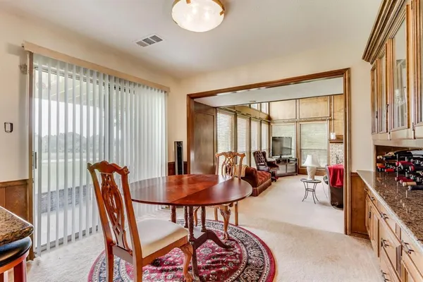 a dining room with furniture and a large window