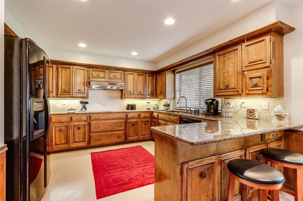 9310 Waterview Road Dallas, TX 75218 - Photo 14 of 35 a kitchen with granite countertop a sink stove refrigerator dining table and chairs