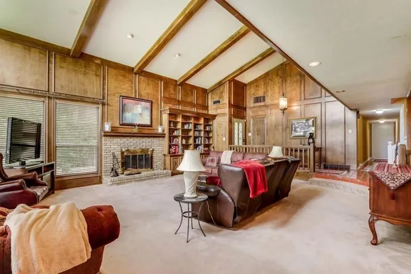 a living room with furniture a fireplace and a flat screen tv
