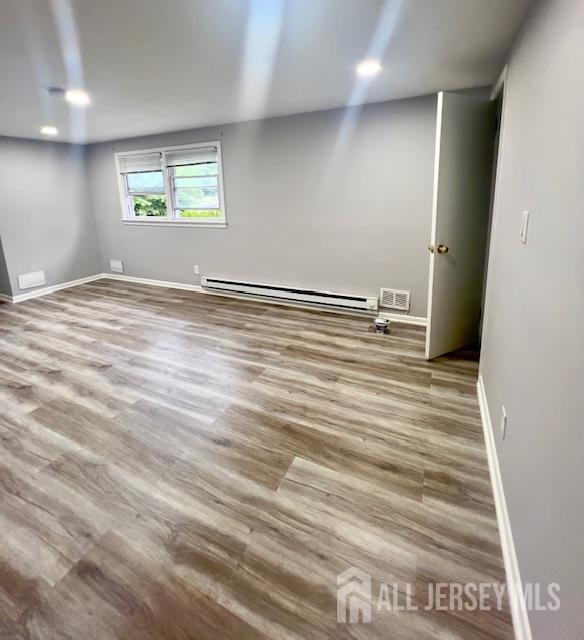 213 Temple Way, Unit 2 Colonia, NJ 07067 - Photo 4 of 16 an empty room with wooden floor and window