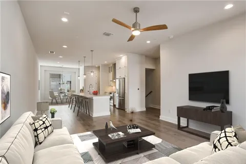 a living room with furniture a rug and a flat screen tv