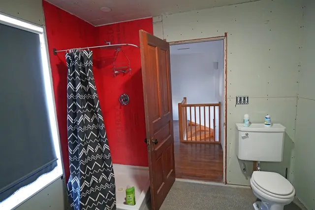 a bathroom with a toilet and a shower
