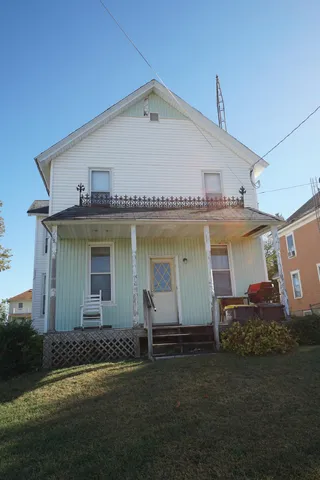 a view of a white house with a yard and plants