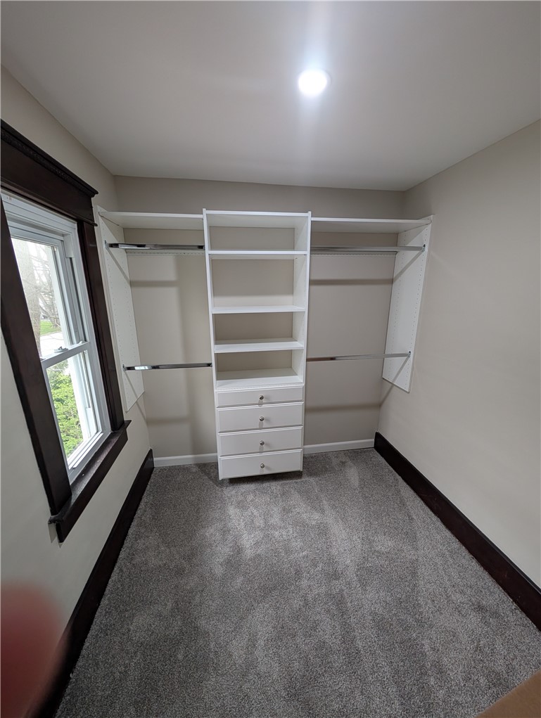 10796 Preble County Line Road Brookville, OH 45309 - Photo 21 of 33 This organized walk-in closet offers convenient storage solutions with built-in shelving and soft carpeting.