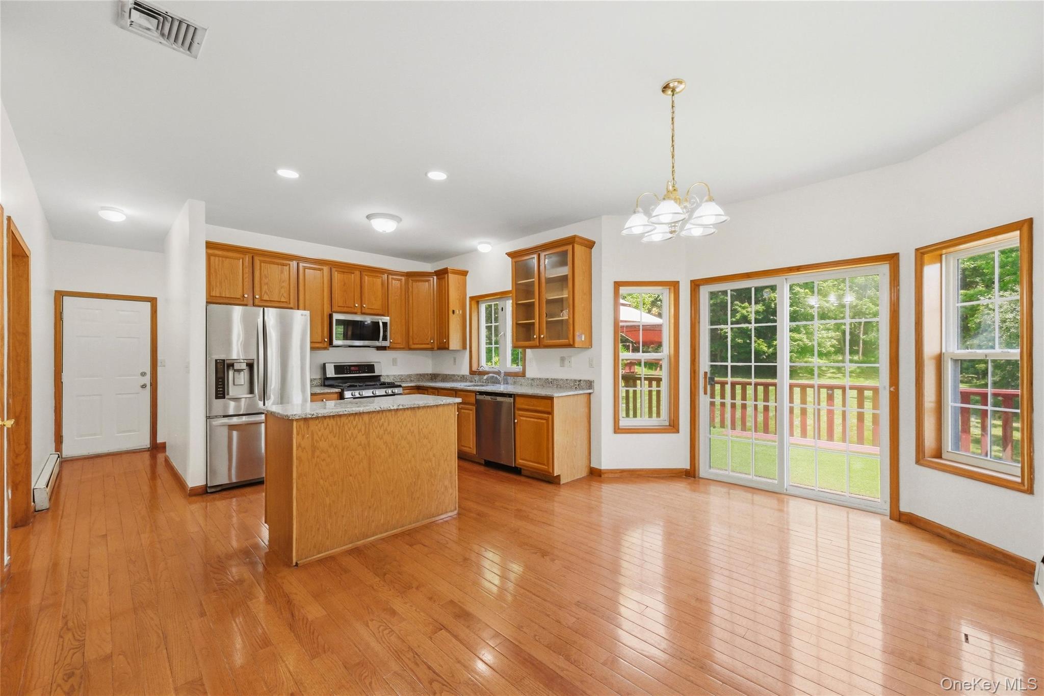 5 Horton Road Washingtonville, NY 10992 - Photo 9 of 42 a open kitchen with stainless steel appliances granite countertop a refrigerator a oven a dining table and chairs with wooden floor