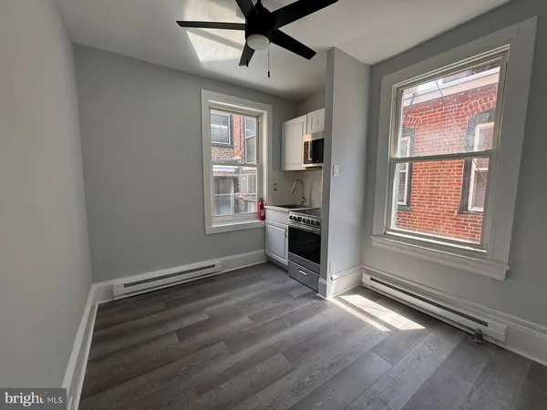 a view of an empty room with a window and wooden floor
