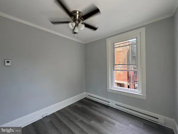 an empty room with a window and a fan