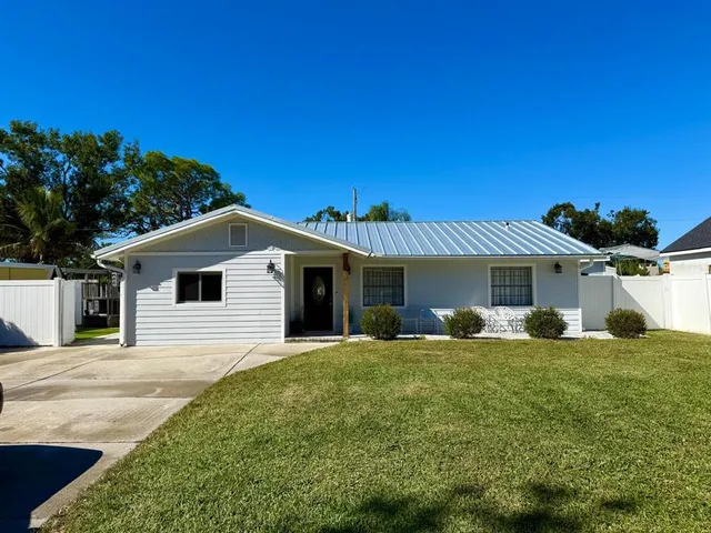 a front view of a house with a yard and trees