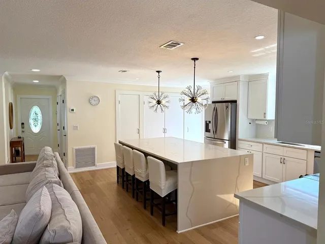 a large kitchen with kitchen island a large counter space a sink and stainless steel appliances