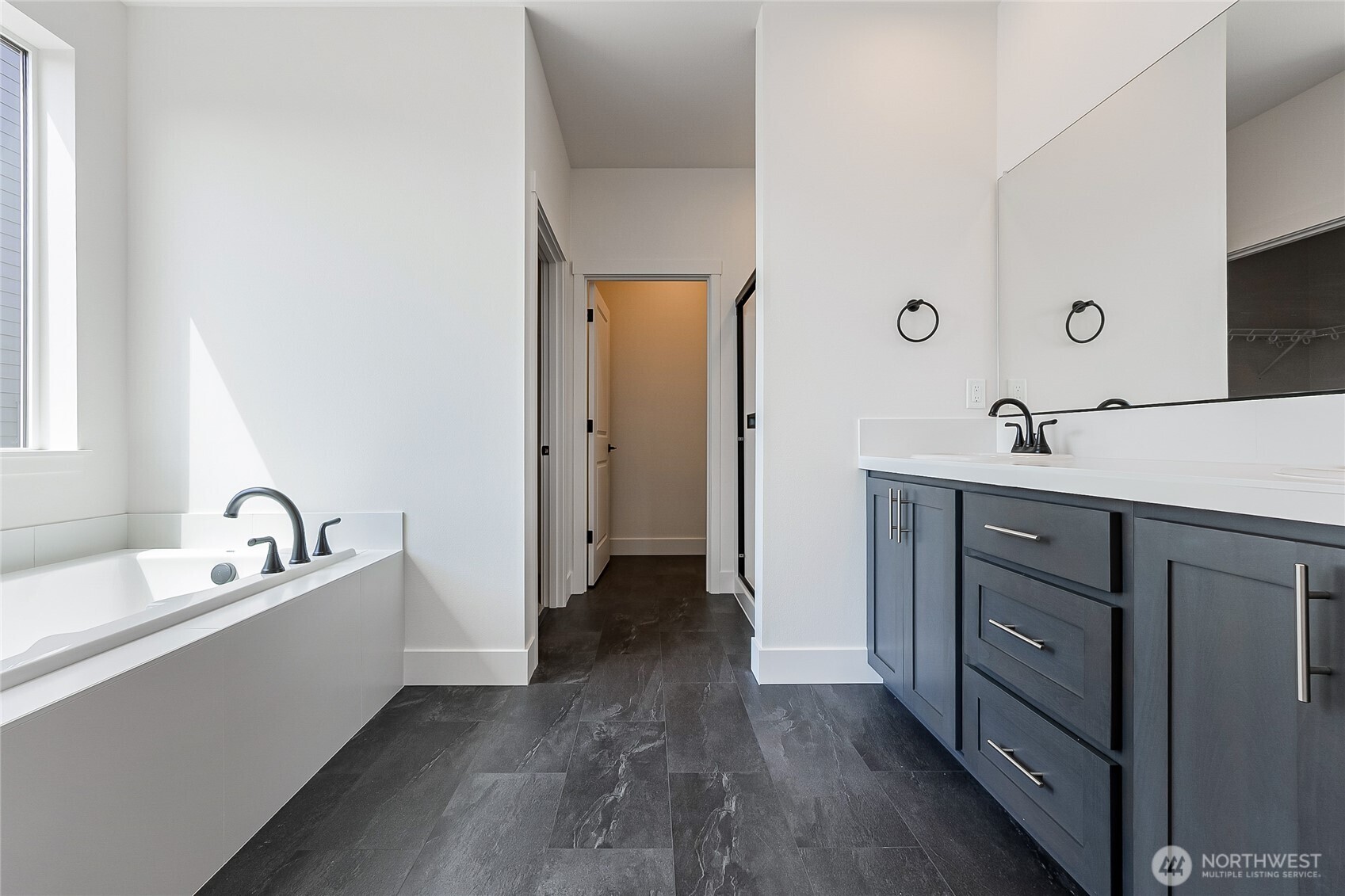 402 Pagget Avenue Winlock, WA 98596 - Photo 16 of 36 a en suite bathroom with a double vanity sink a mirror and a bathtub