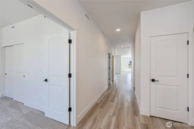 a view of a hallway with wooden floor
