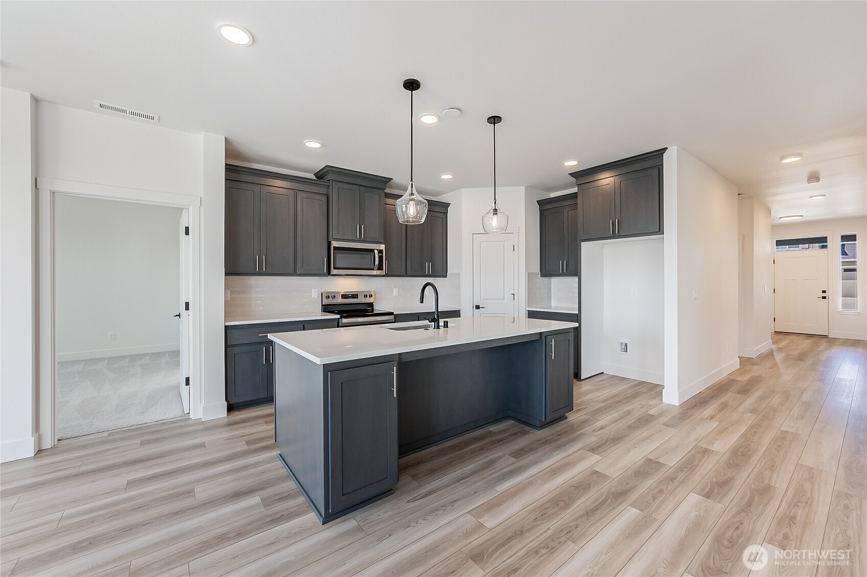 402 Pagget Avenue Winlock, WA 98596 - Photo 8 of 36 a large kitchen with a large counter top a sink stainless steel appliances and cabinets
