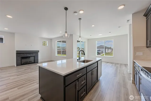 a kitchen with a sink stove and wooden floor