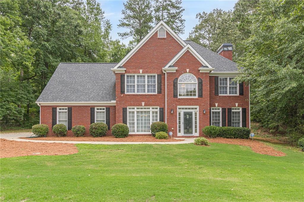 a front view of house with yard and green space