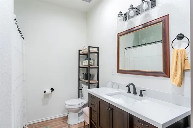 a bathroom with a sink vanity mirror and toilet