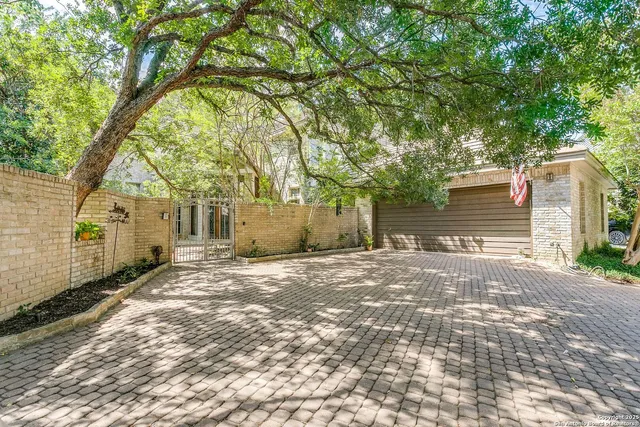 a backyard of a house with large trees and outdoor shower