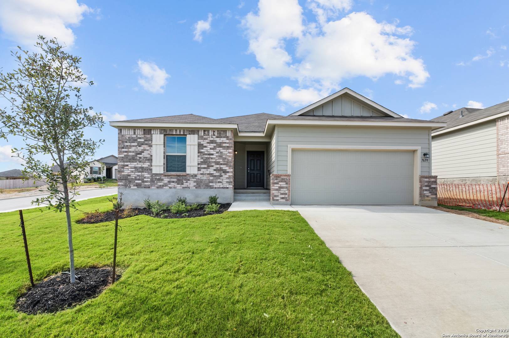 a front view of a house with a yard and garage